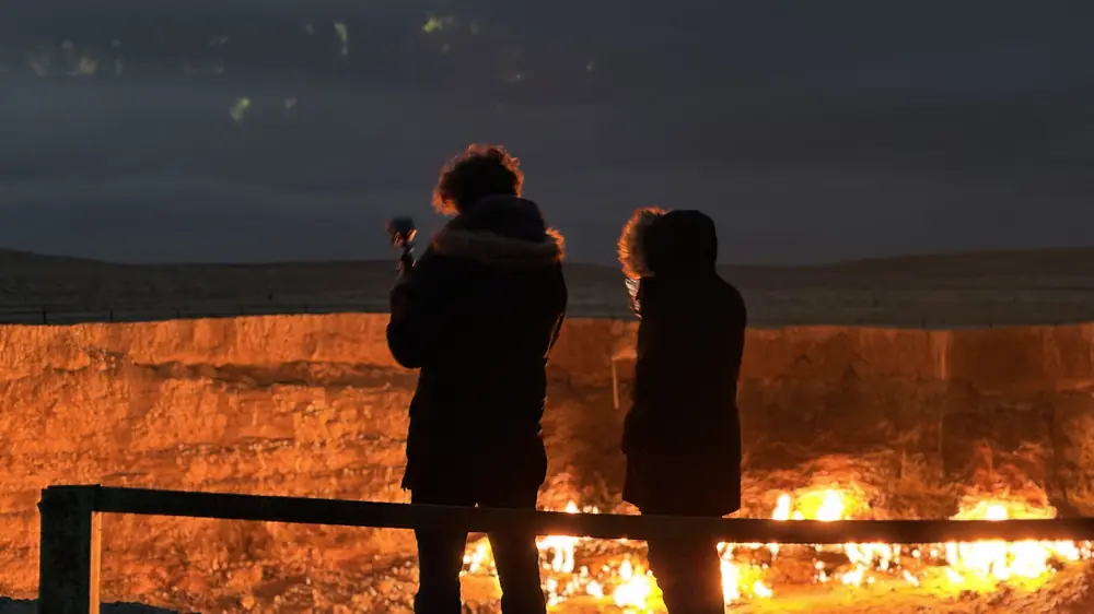 Travelers at the Darvaza gas crater at night